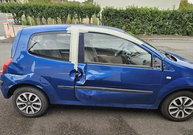 Avant : une voiture bleue, portière enfoncée après un accident